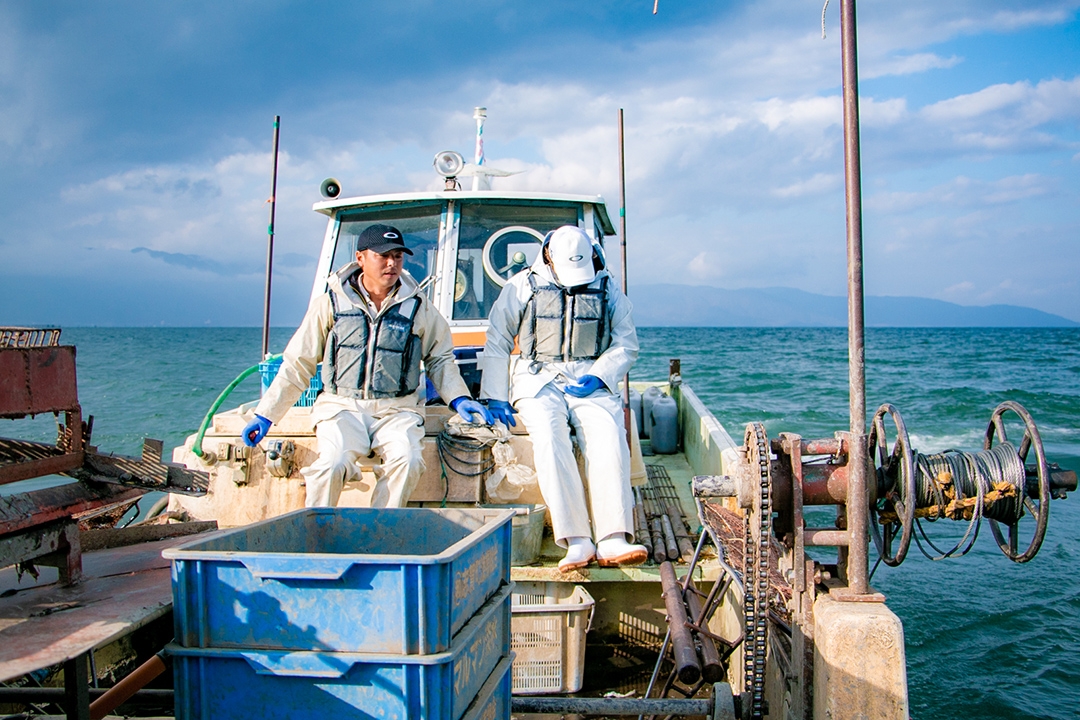 船から網を下ろす漁師の今井良平さん