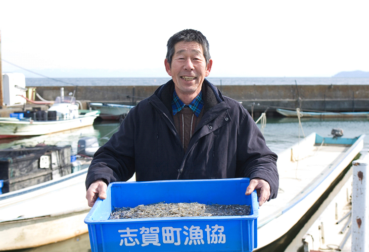 和邇漁港で、水揚げされたばかりの氷魚を持つ礒田組合長